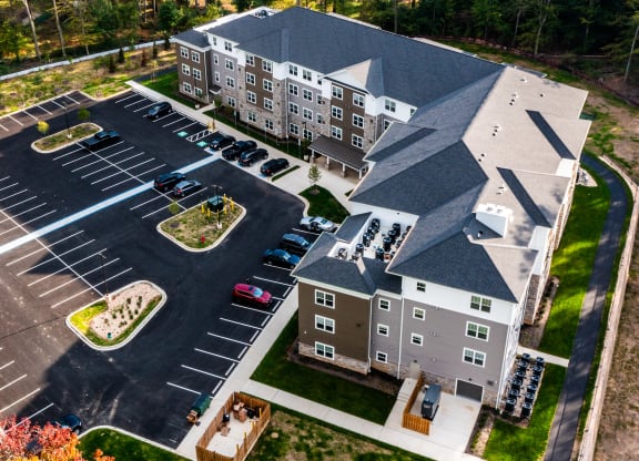 an aerial view of an apartment building with parking lot and street