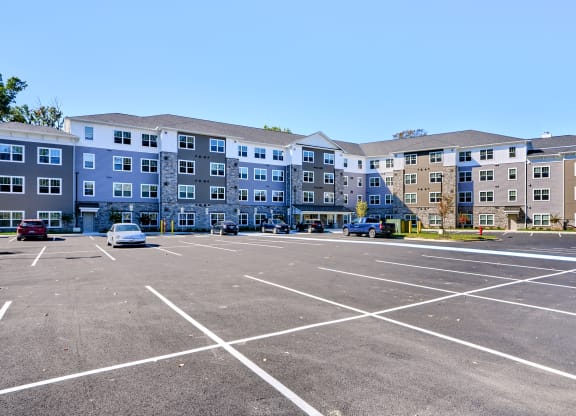 an empty parking lot in front of an apartment building