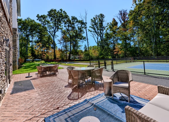 a backyard with a tennis court and patio furniture