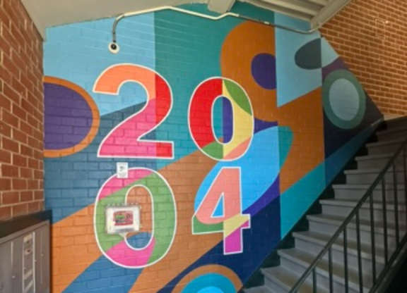 A staircase with a colorful 2014 mural on the wall.