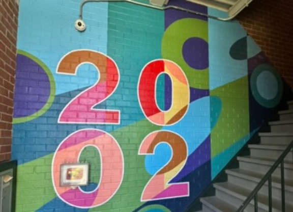 A staircase with a colorful 2020 sign on the wall.