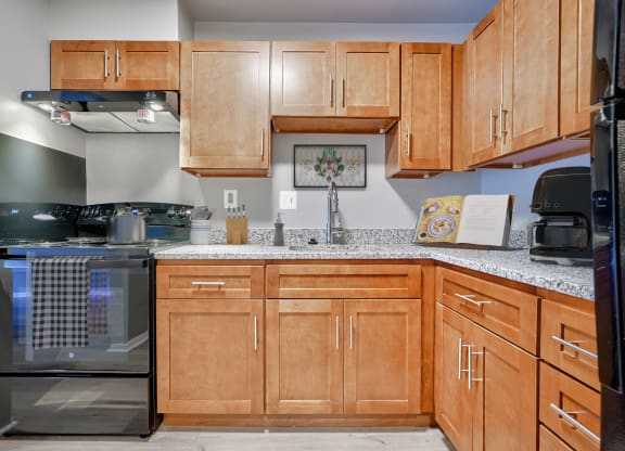 an empty kitchen with wooden cabinets and granite counter tops