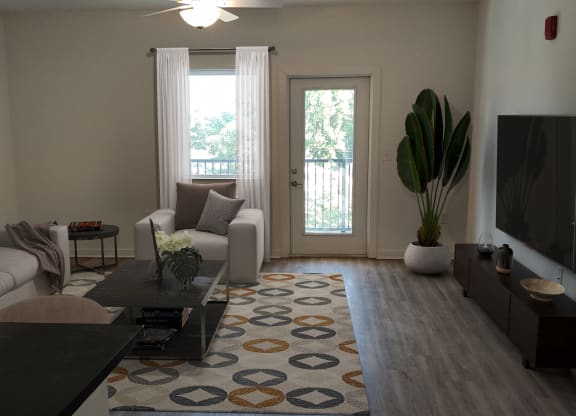 an empty living room with a rug in the middle