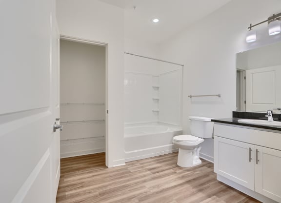 a white bathroom with a toilet and a shower