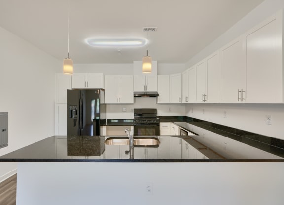 a large kitchen with white cabinets and black counter tops