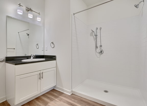a white bathroom with a shower and a sink