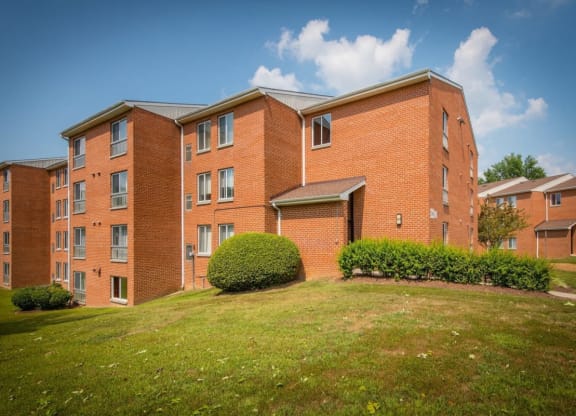 a large brick building with a green lawn in front of it