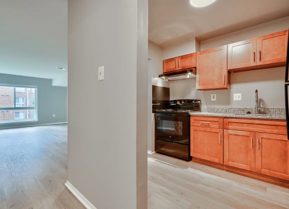 a kitchen and living room with wood cabinets and black appliances