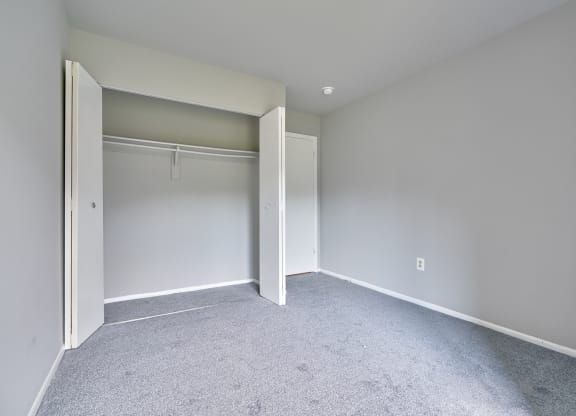 an empty bedroom with white walls and a closet