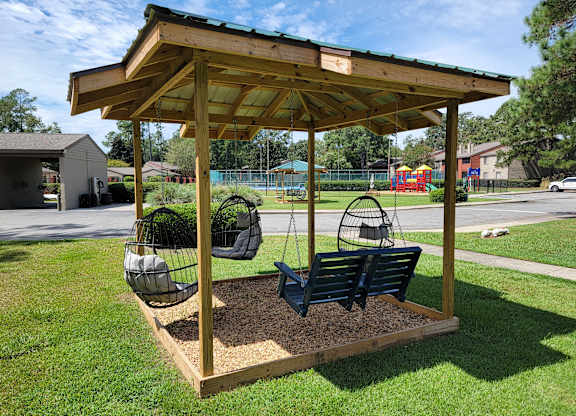 a swing set in a park with a gazebo