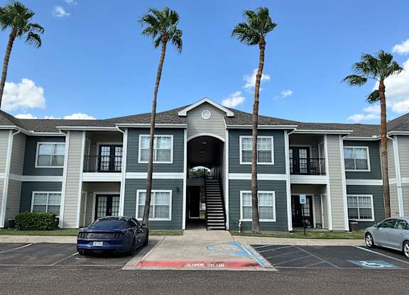 a large apartment building with palm trees in front of it