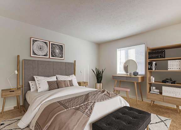 A bedroom with a large bed and a desk with a chair.