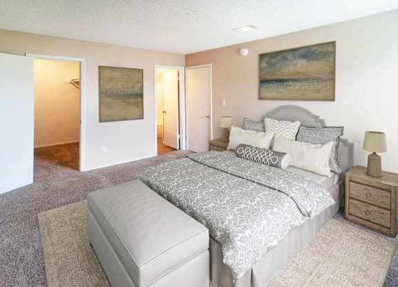 A bedroom with a large bed and a painting on the wall.