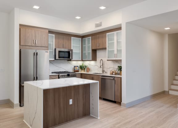 a kitchen with a large island and stainless steel appliances