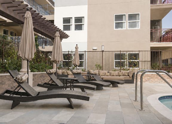 A patio with a pool and a table with chairs.
