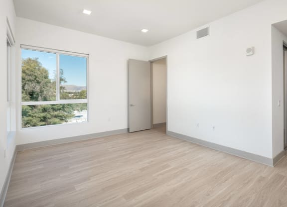 an empty room with white walls and a window