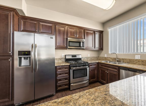 a kitchen with stainless steel appliances and granite counter tops at Le Blanc Apartment Homes, Canoga Park, CA