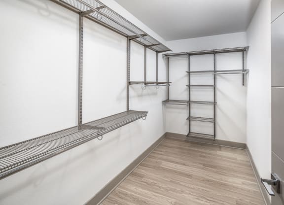 a empty room with a white wall and a mirrored closet with a ladder