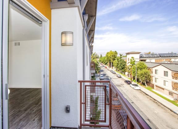 a balcony with a view of the street and a door to a apartment building