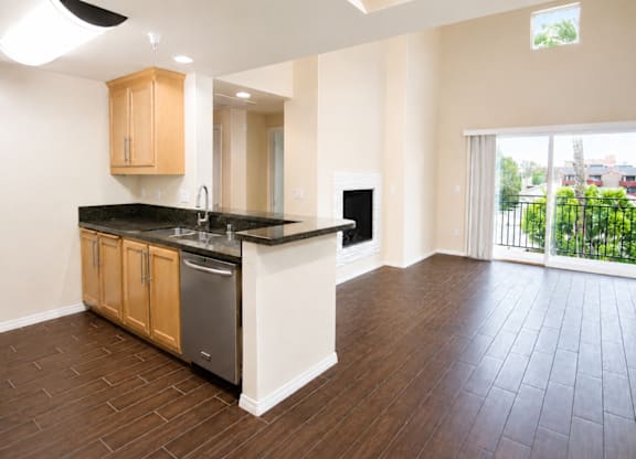 A kitchen with wooden cabinets and black countertops.