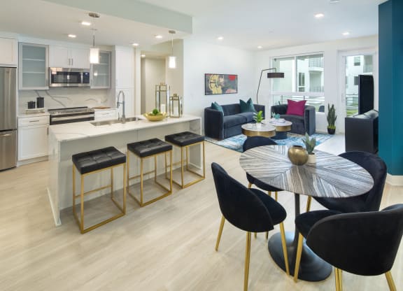a living room and kitchen with a table and chairs