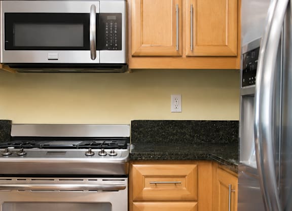 A kitchen with a stainless steel refrigerator, oven, and microwave.