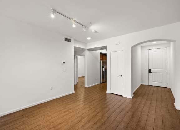 a living room with wood floors and white walls and white doors at Le Blanc Apartment Homes, Canoga Park, CA