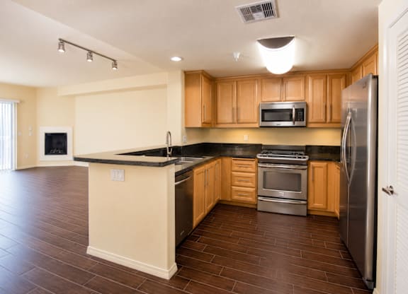 A kitchen with wooden cabinets and a black counter top.