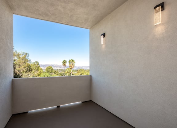 a room with a large window and a view of palm trees