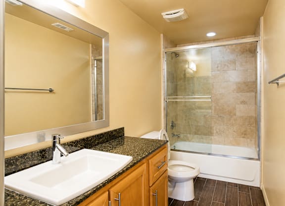 A bathroom with a sink, toilet, and shower.