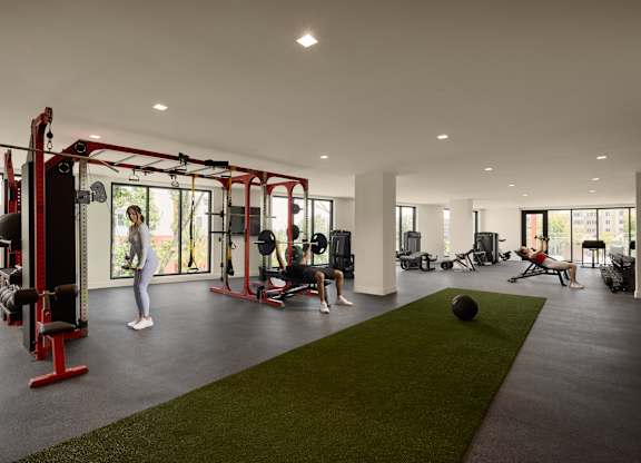 A woman is working out in a gym with a variety of equipment.