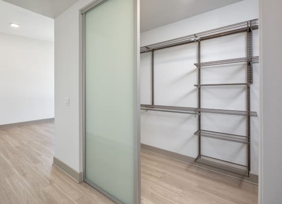 a mirrored closet door in a room with wood floors and white walls