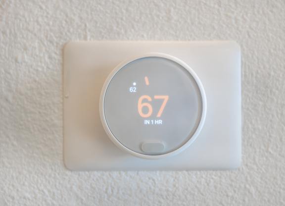 A thermostat showing a temperature of 67 degrees.