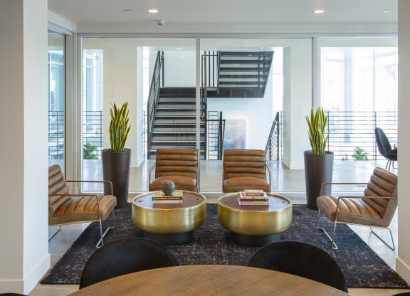 a lobby with chairs and tables and a staircase