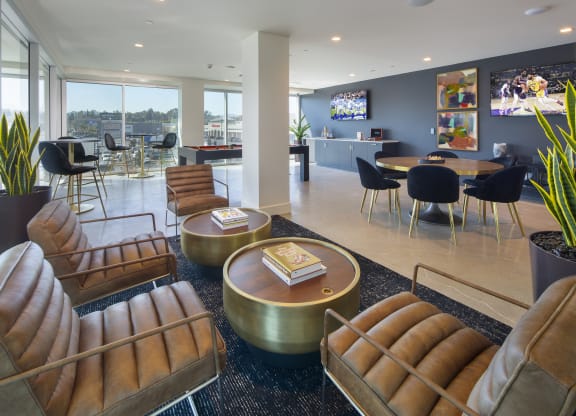 a lounge area with chairs and tables and a television