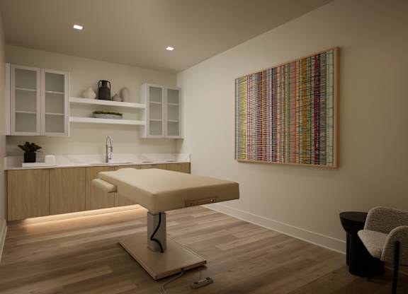 A room with a massage table and a chair.