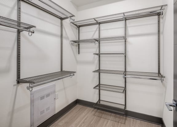 a walk in closet with empty shelves and a door