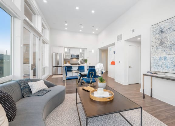 Two-Bedroom Apartments in Woodland Hills, CA - The Q Variel - Living Room with Luxury Wood Plank Style Flooring, High Ceilings, Oversized Windows, and Access to the Dining Area and Kitchen