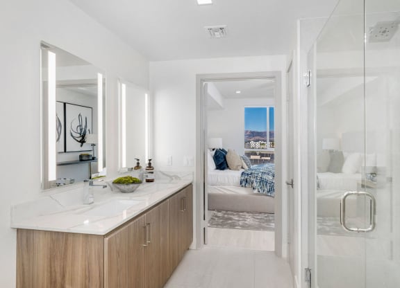 a bathroom with a shower and a sink and a bedroom