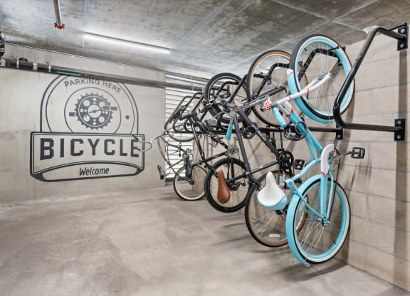 a group of bikes hanging on a wall in a bike garage