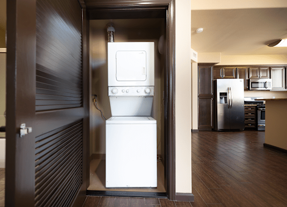A white oven is in a kitchen with a dark brown door.