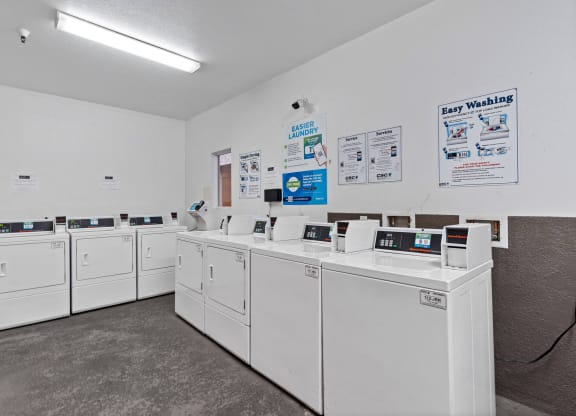 a row of washers and dryers in a laundromat with white machines at Dronfield Astoria, Sylmar, California