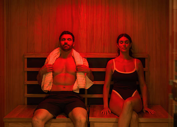 A man and a woman are sitting in a sauna.