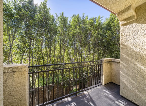balcony with iron fence looking out to green trees at The Village Apartments, Van Nuys