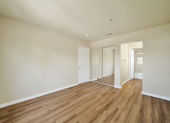 a bedroom with wood floors and white walls