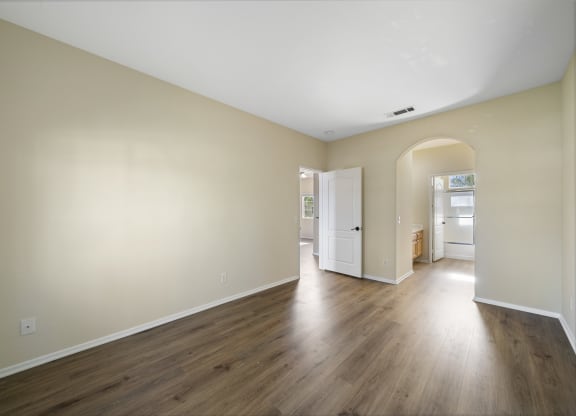 a bedroom with hardwood floors and beige walls at The Village Apartments, Van Nuys, 91406