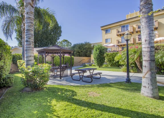 a backyard with a picnic table and a gazebo