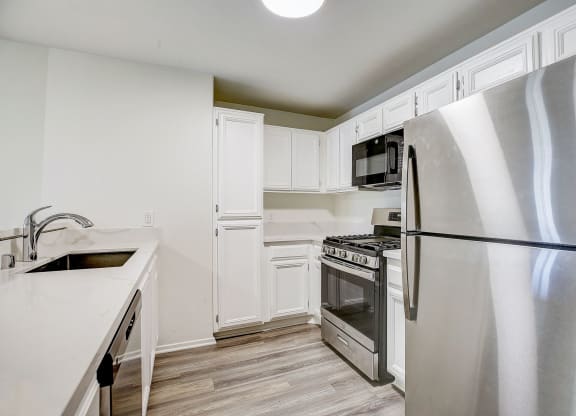 a kitchen with stainless steel appliances and white cabinets