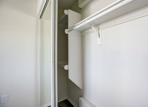 an empty closet with a white wall and a sliding glass door