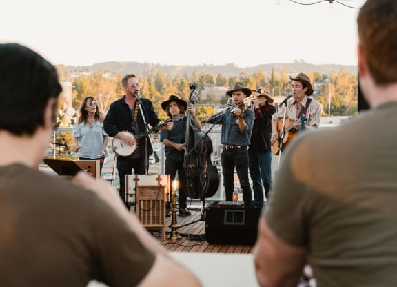 a group of musicians playing instruments on a stage with people watching